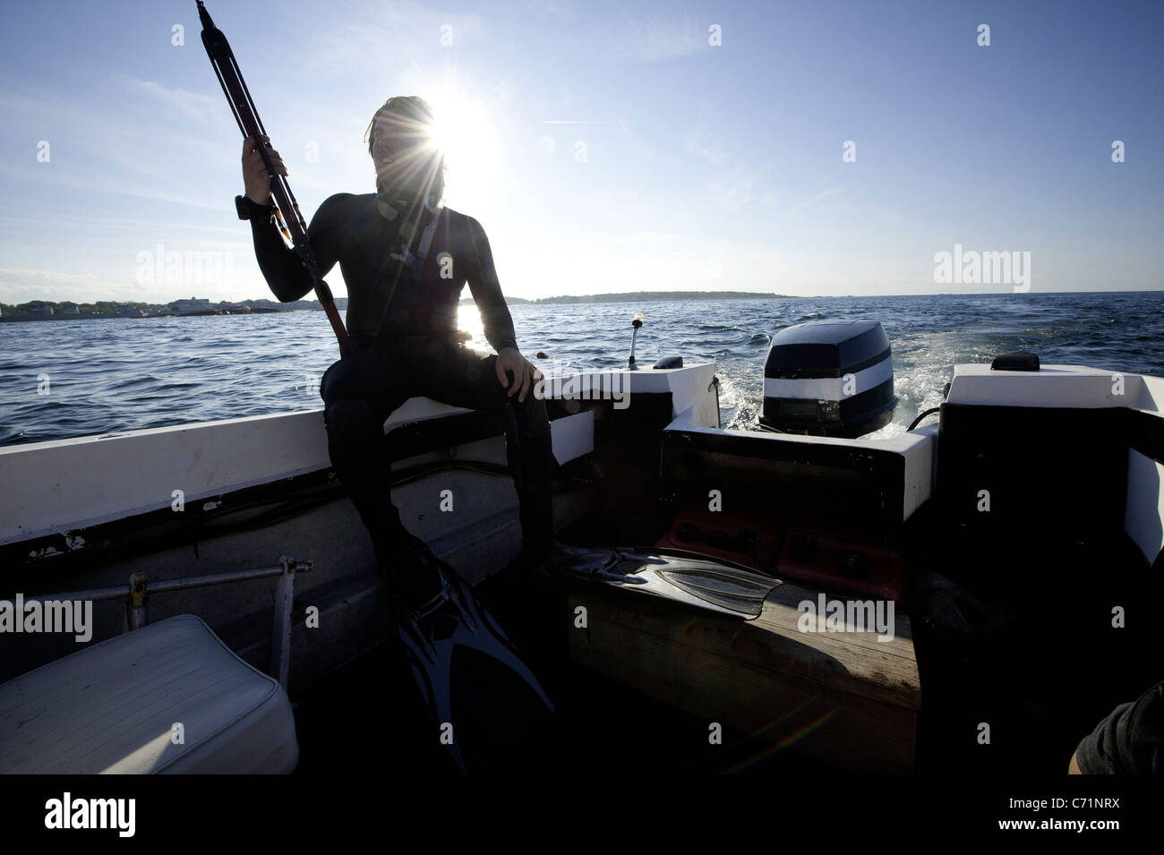 A man gets his spearfishing gear ready as the sun begins to set Stock Photo  - Alamy