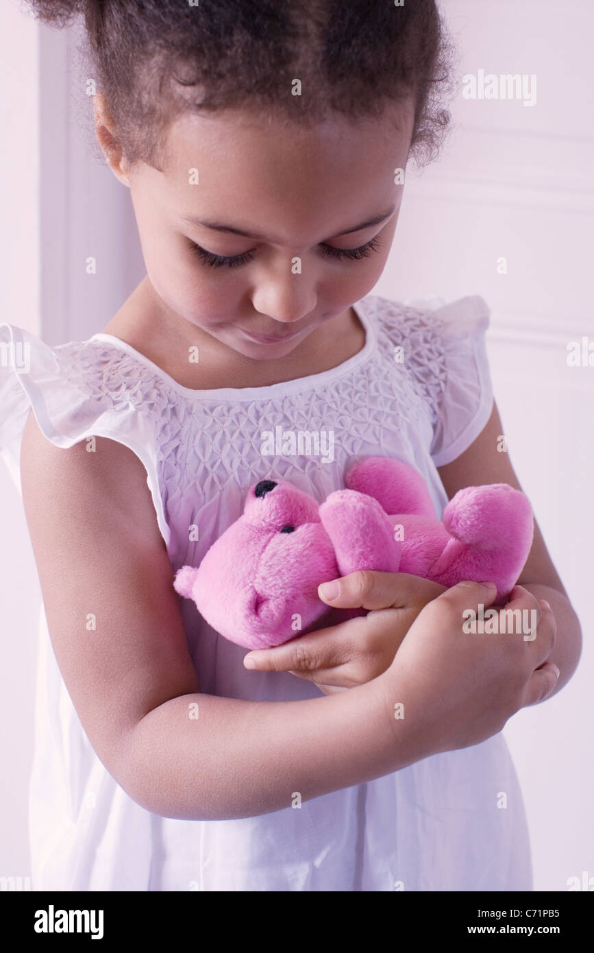Little girl holding teddy bear affectionately Stock Photo - Alamy