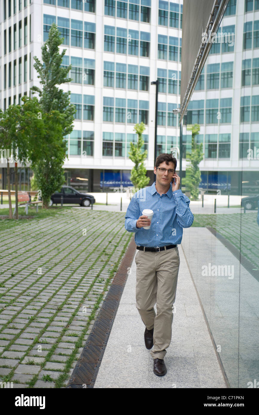 Man talking on cell phone while walking in city Stock Photo