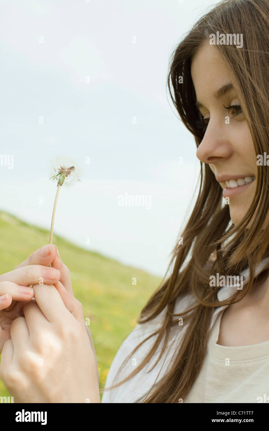 Young woman holding dandelion flower Stock Photo