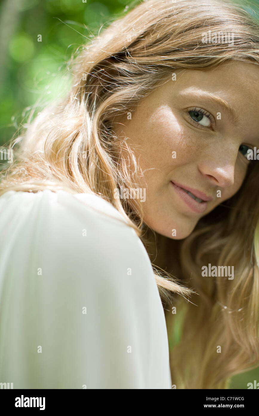 Young woman smiling over shoulder at camera, portrait Stock Photo