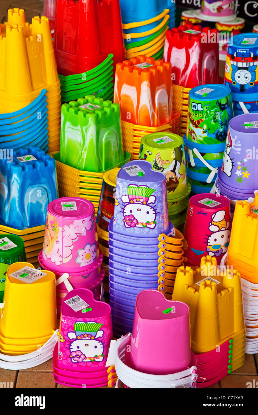 Brightly coloured children's toy plastic beach buckets on display outside a seaside shop. Stock Photo