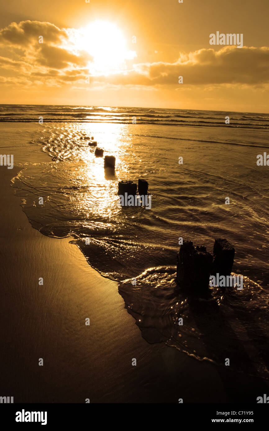 wave breakers at sunset on a golden beach in youghal county cork ireland Stock Photo Alamy