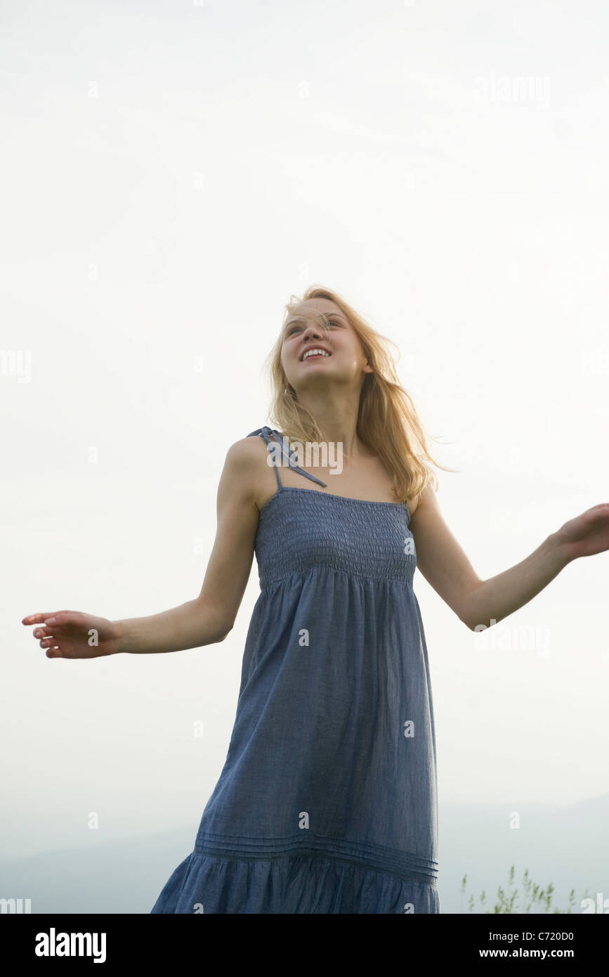 Young woman outdoors, looking up Stock Photo