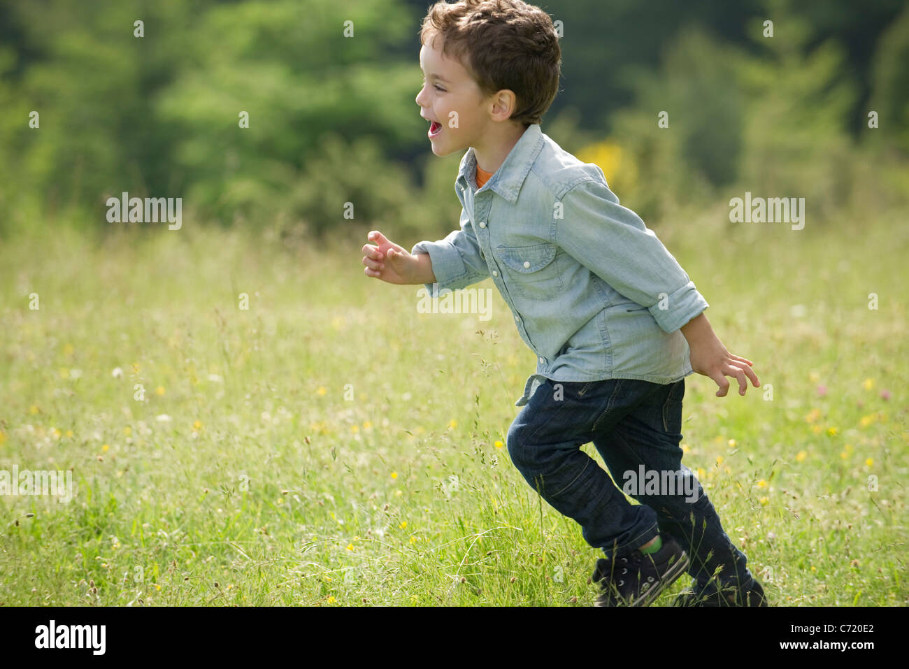 Little boy running in field Stock Photo