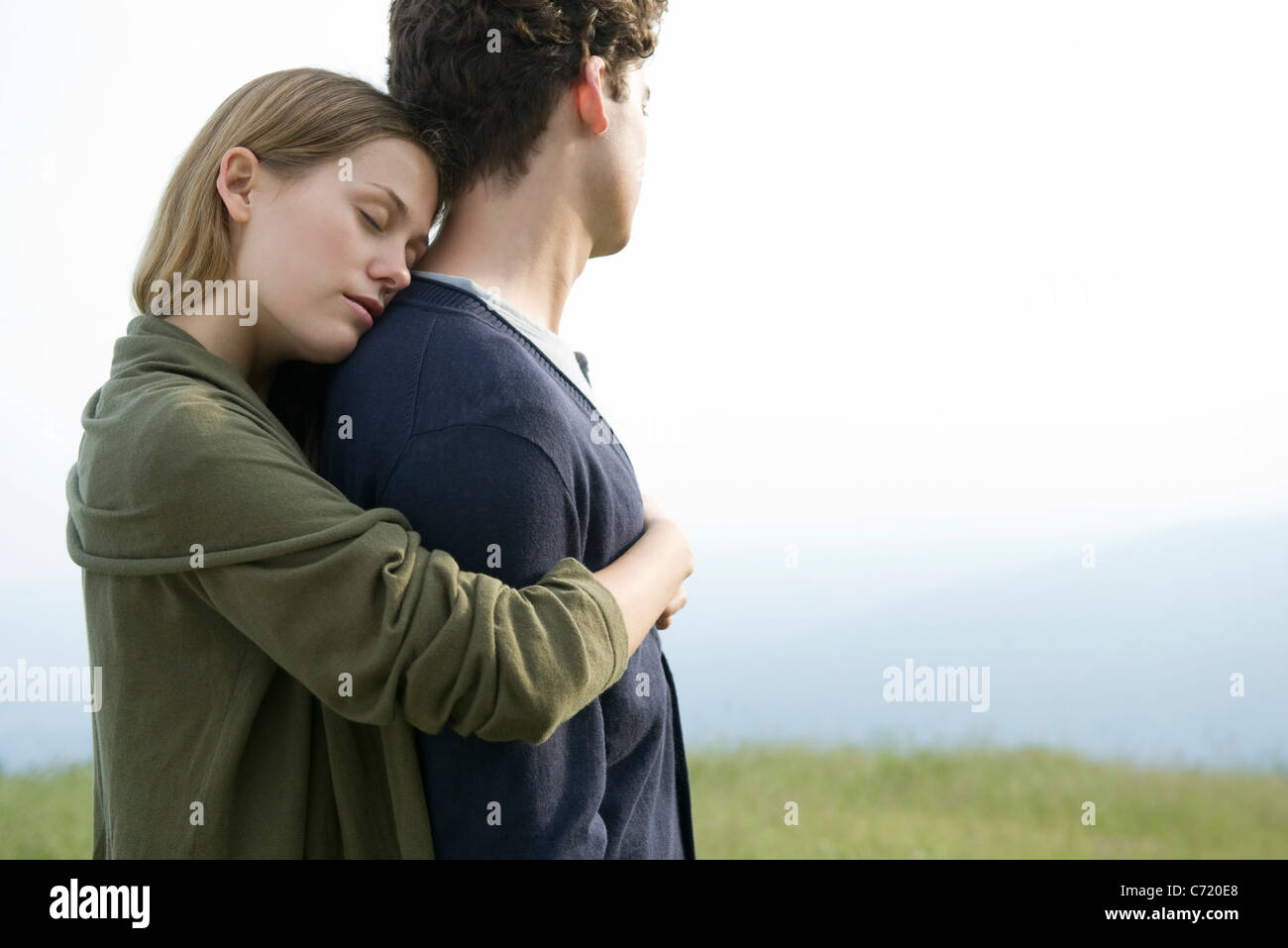 Young woman hugging boyfriend Stock Photo - Alamy