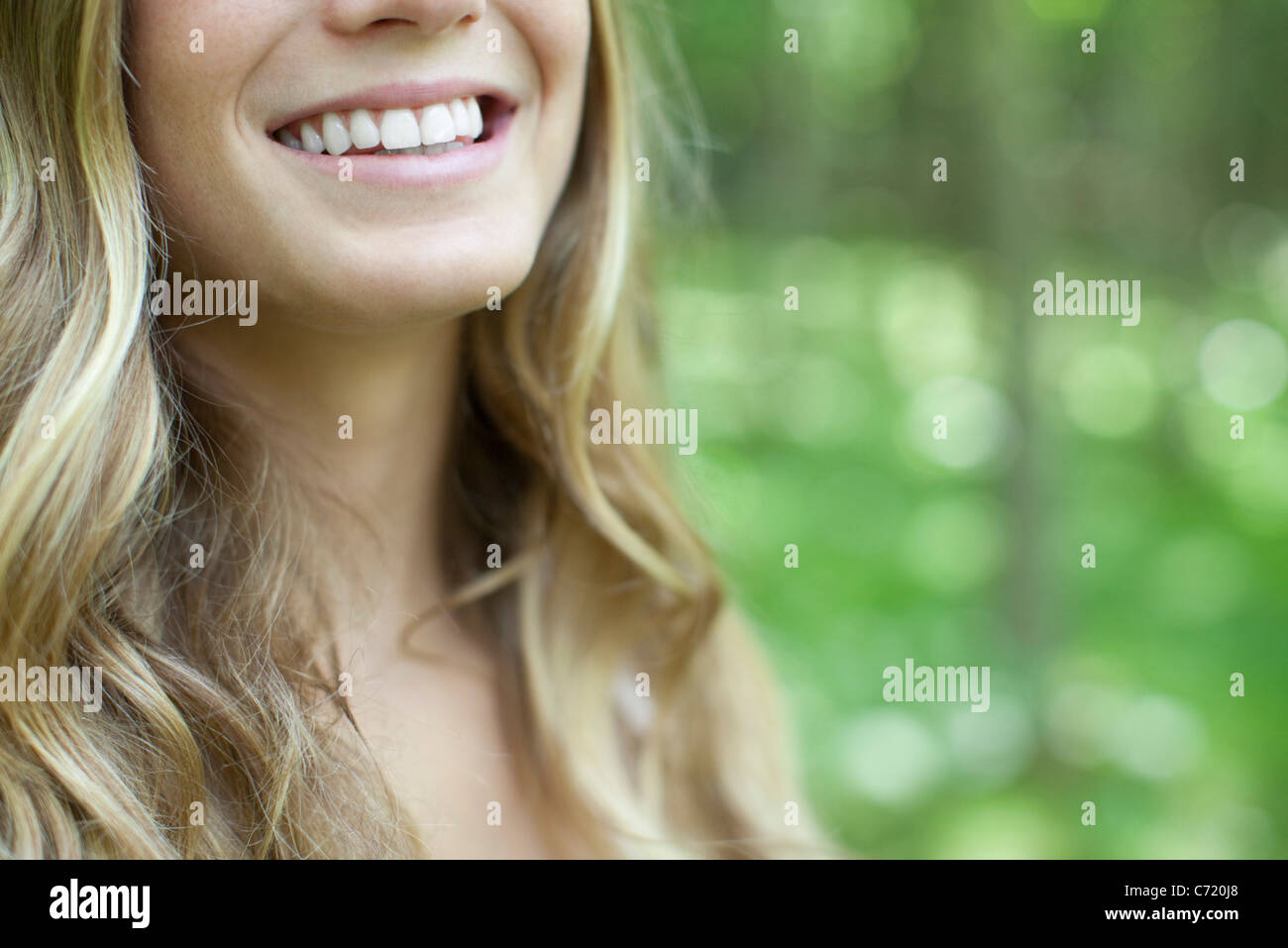 Young woman with toothy smile, cropped Stock Photo - Alamy