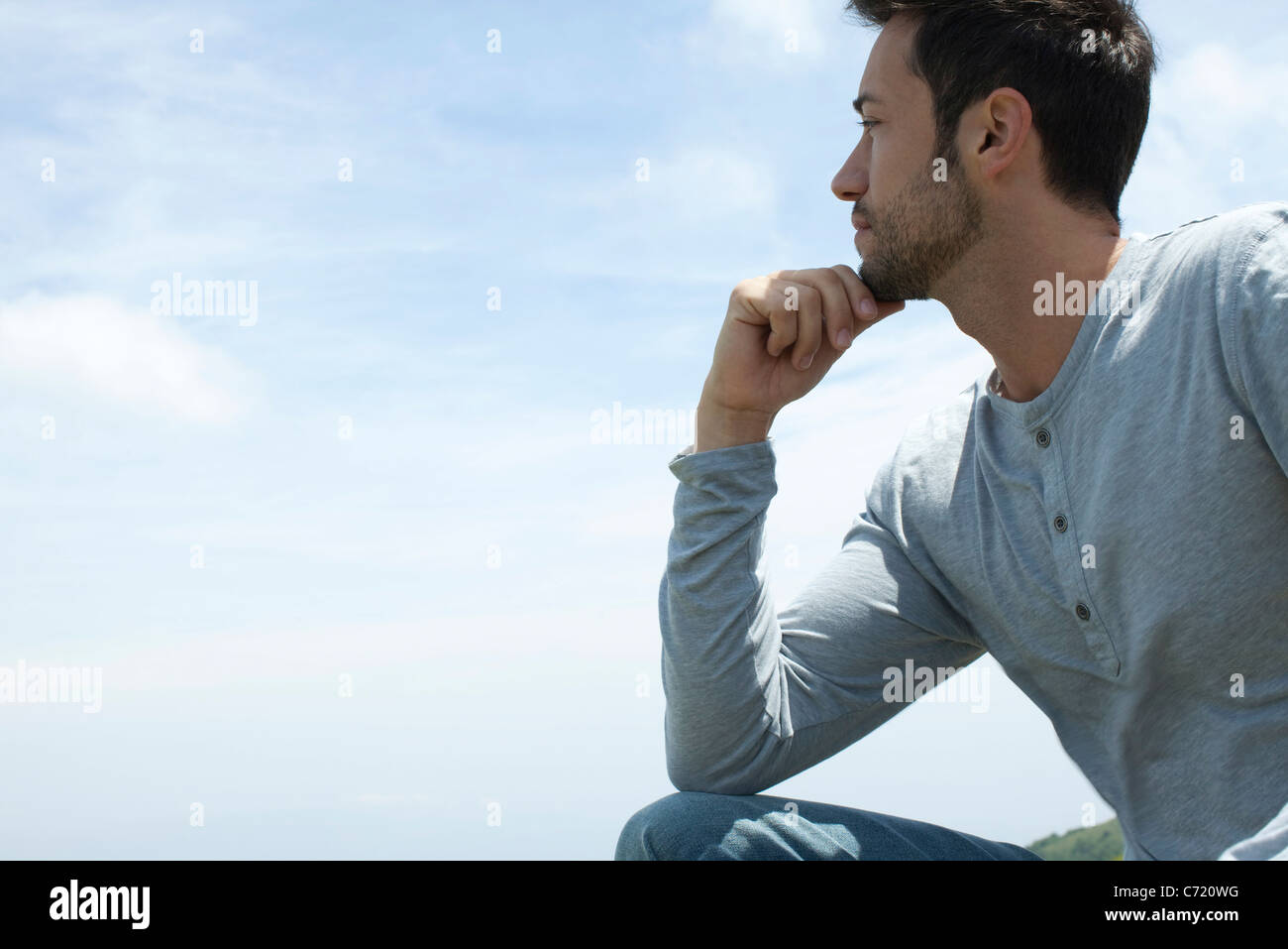 Man resting chin on hand, looking at view Stock Photo Alamy