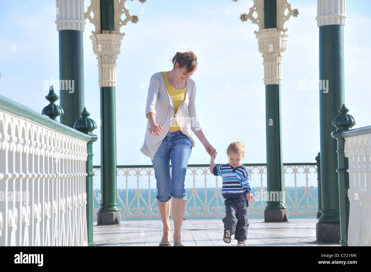 Mother and toddler son walking hand in hand, Brighton Bandstand (Birdcage), UK Stock Photo