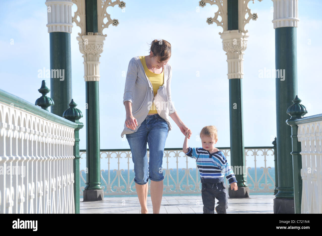 Mother and toddler son walking hand in hand, Brighton Bandstand (Birdcage), UK Stock Photo