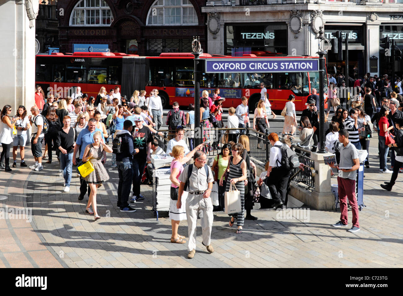 London street scene crowd of people around Oxford Circus & underground tube station at busy retail shopping area & West End road junction England UK Stock Photo