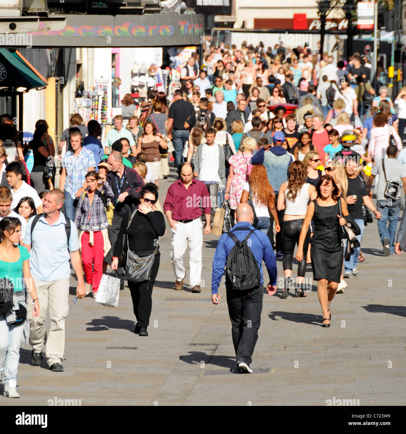 View from above crowd of people shoppers & tourists walking on busy pavement West End retail shopping street summer in London England UK Stock Photo