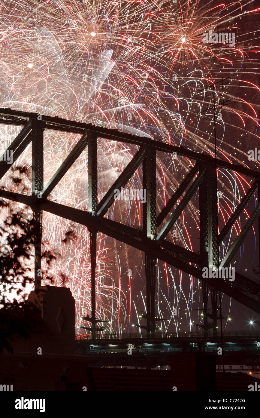 Silhouette of fireworks display behind Sydney Harbour Bridge on New Years eve. Stock Photo