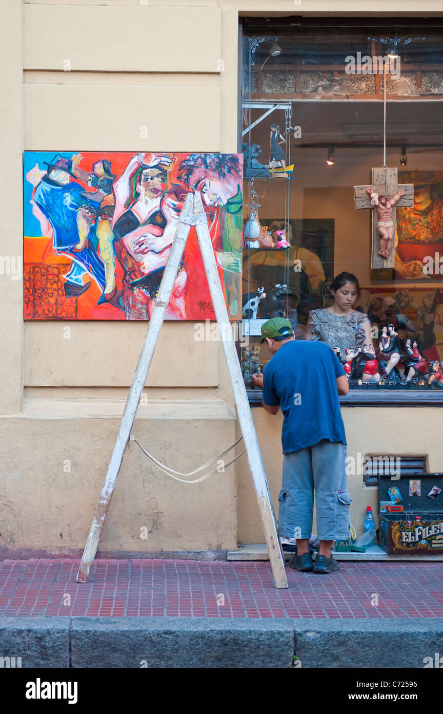 Man and woman decorating a shop window, San Telmo, Buenos Aires, Argentina Stock Photo