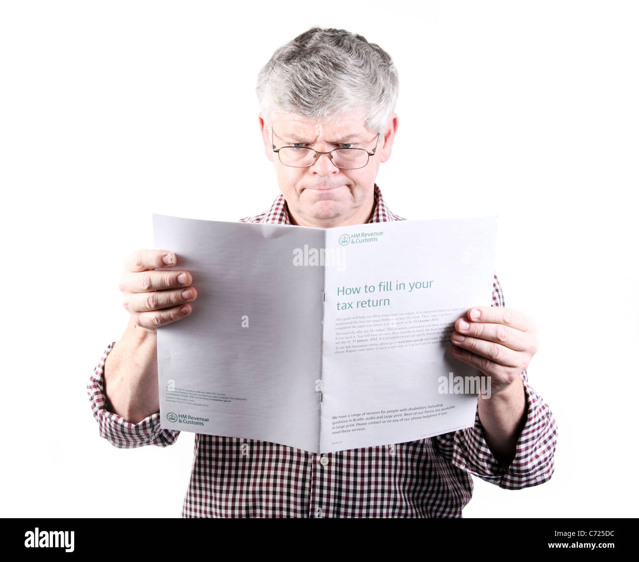 Personal Finance Concept; Middle Aged Man Reading Inland Revenue Tax Return Help Pamphlet Stock Photo