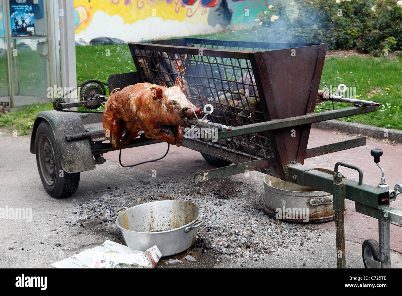Spit roast in the street Pigs roasting on an open spindle barbeque Stock Photo