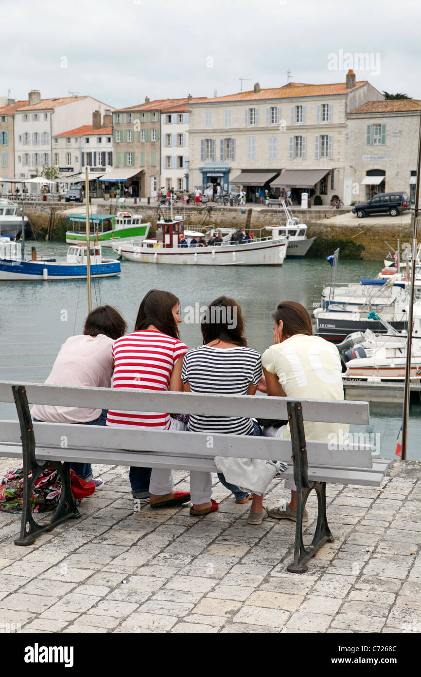 Young ladies chatting on a bench, St Martin harbour Ile de Re Stock Photo