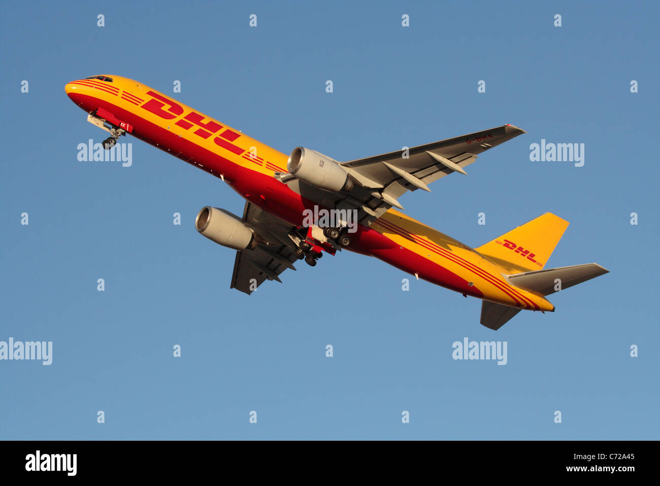 Freight transport by air. DHL Boeing 757-200F cargo jet plane taking off at sunset. International trade. Global route network. Civil aviation. Stock Photo
