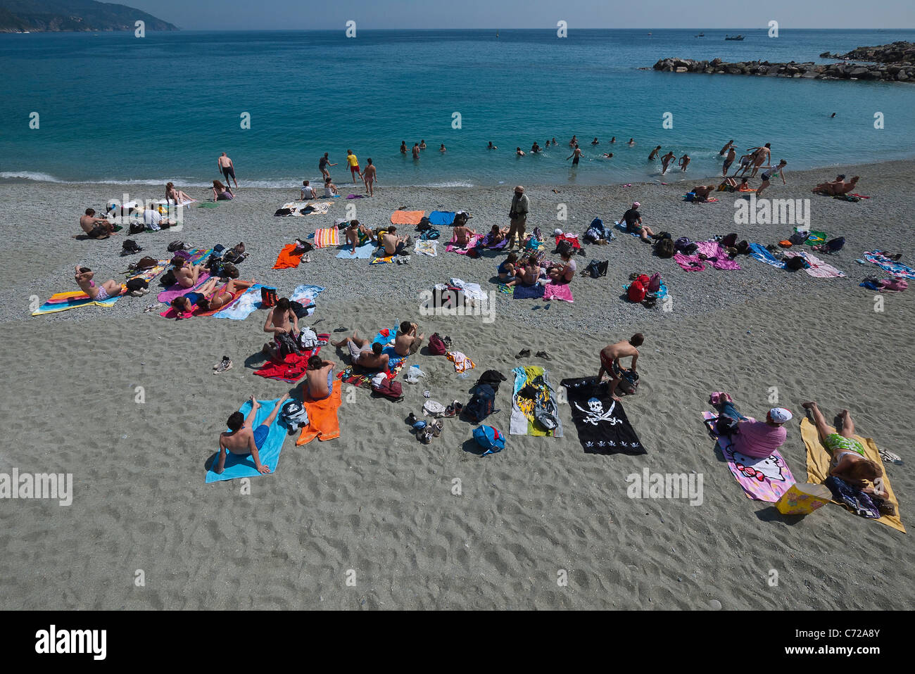 Sunbathers relax on the beach at Monterosso al Mare, Cinque Terre, Italy by the Ligurian Sea. Stock Photo