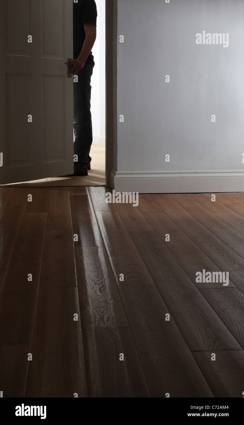 Shape of a man standing by a partially open door. Stock Photo