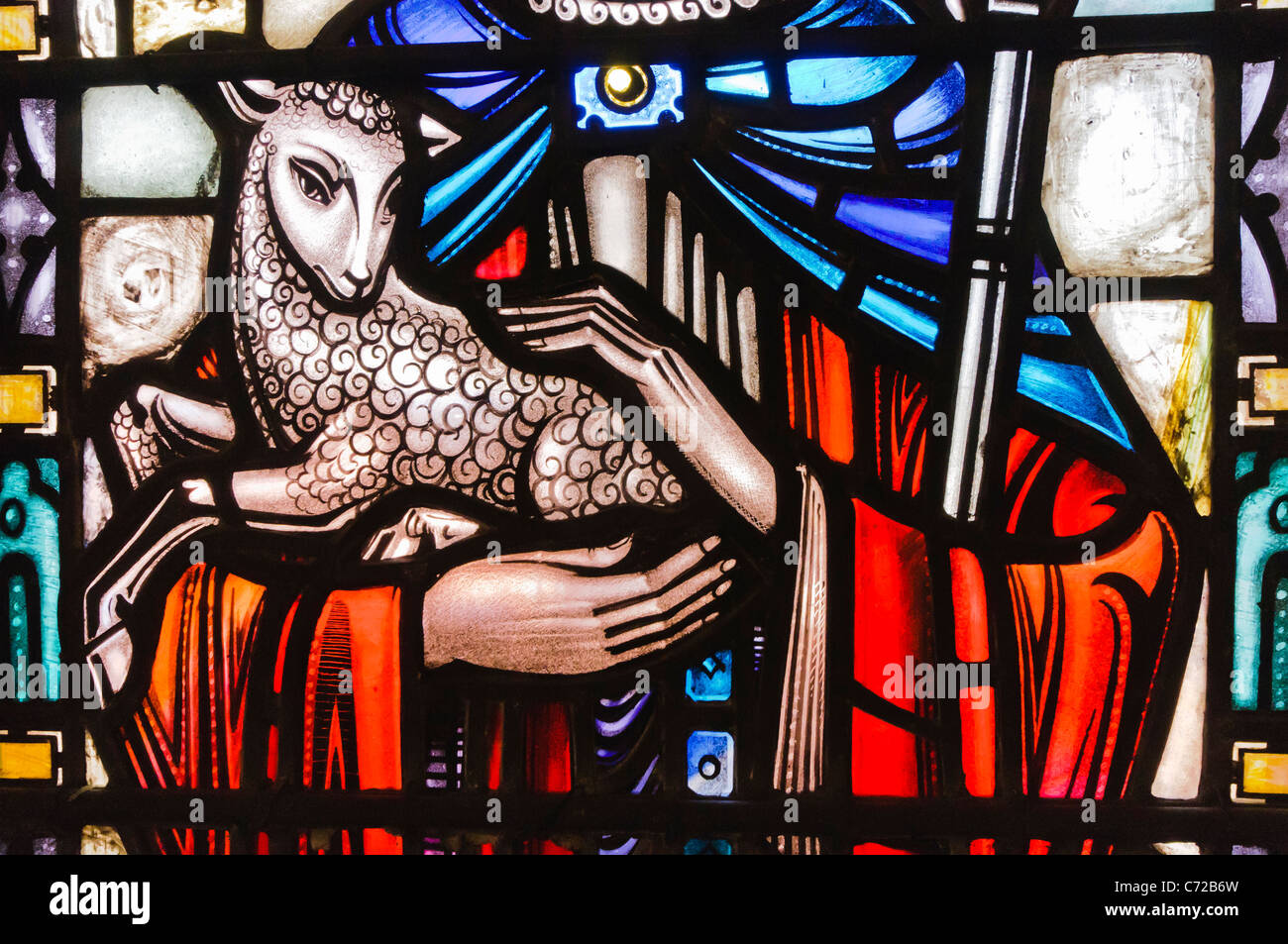 Stained glass window in a church showing Jesus holding a lamb and depicted as a shepherd Stock Photo