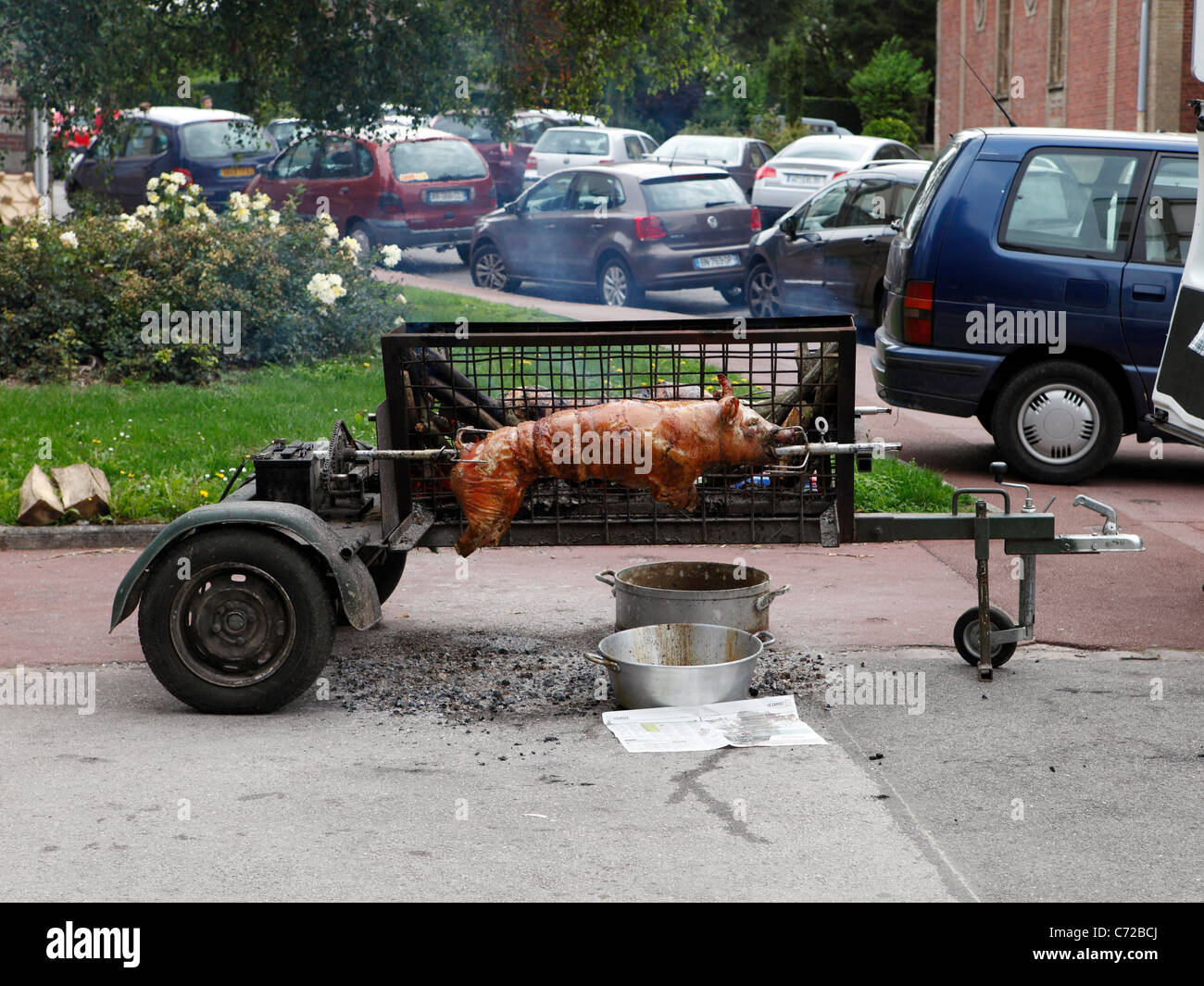 Spit roast in the street Pigs roasting on an open spindle barbeque Stock Photo