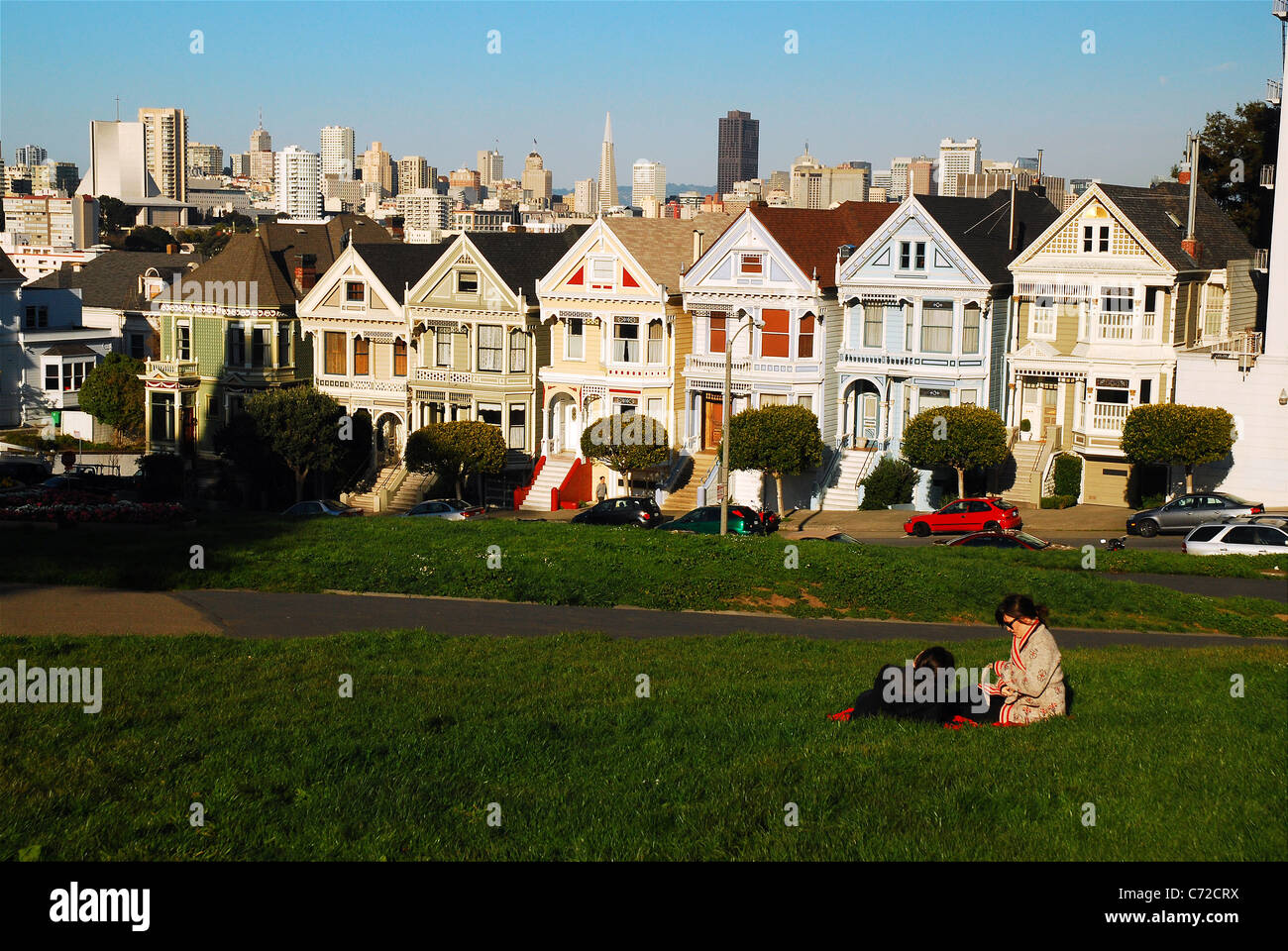 Two people enjoy the nice weather at Alamo Square in San Francisco