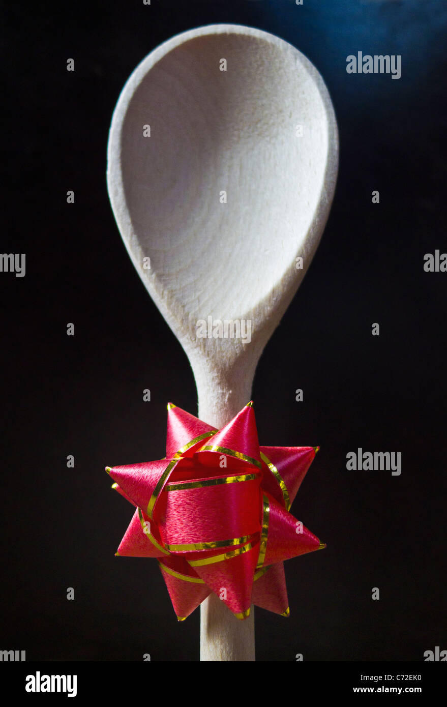 A wooden spoon with a rosette attached to the stem of the handle. Stock Photo