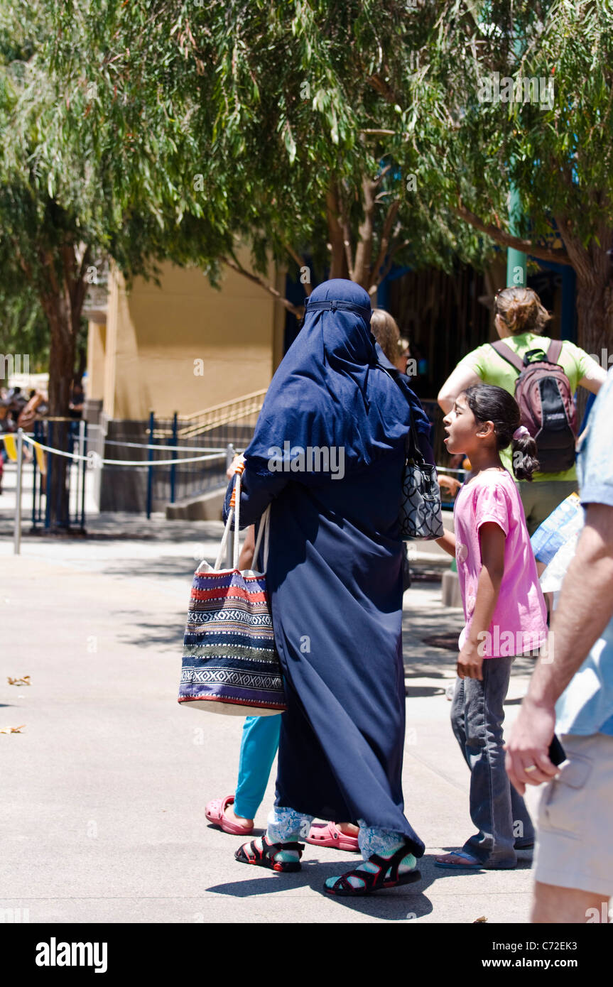 Muslim woman wearing a Burka, walking with children Stock Photo