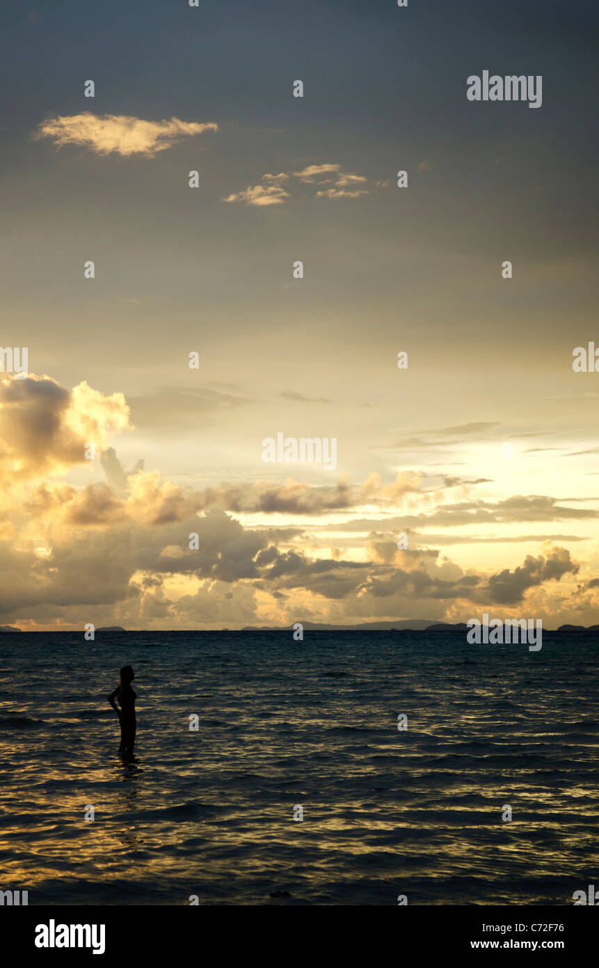 tropical sunset with tourist woman Stock Photo