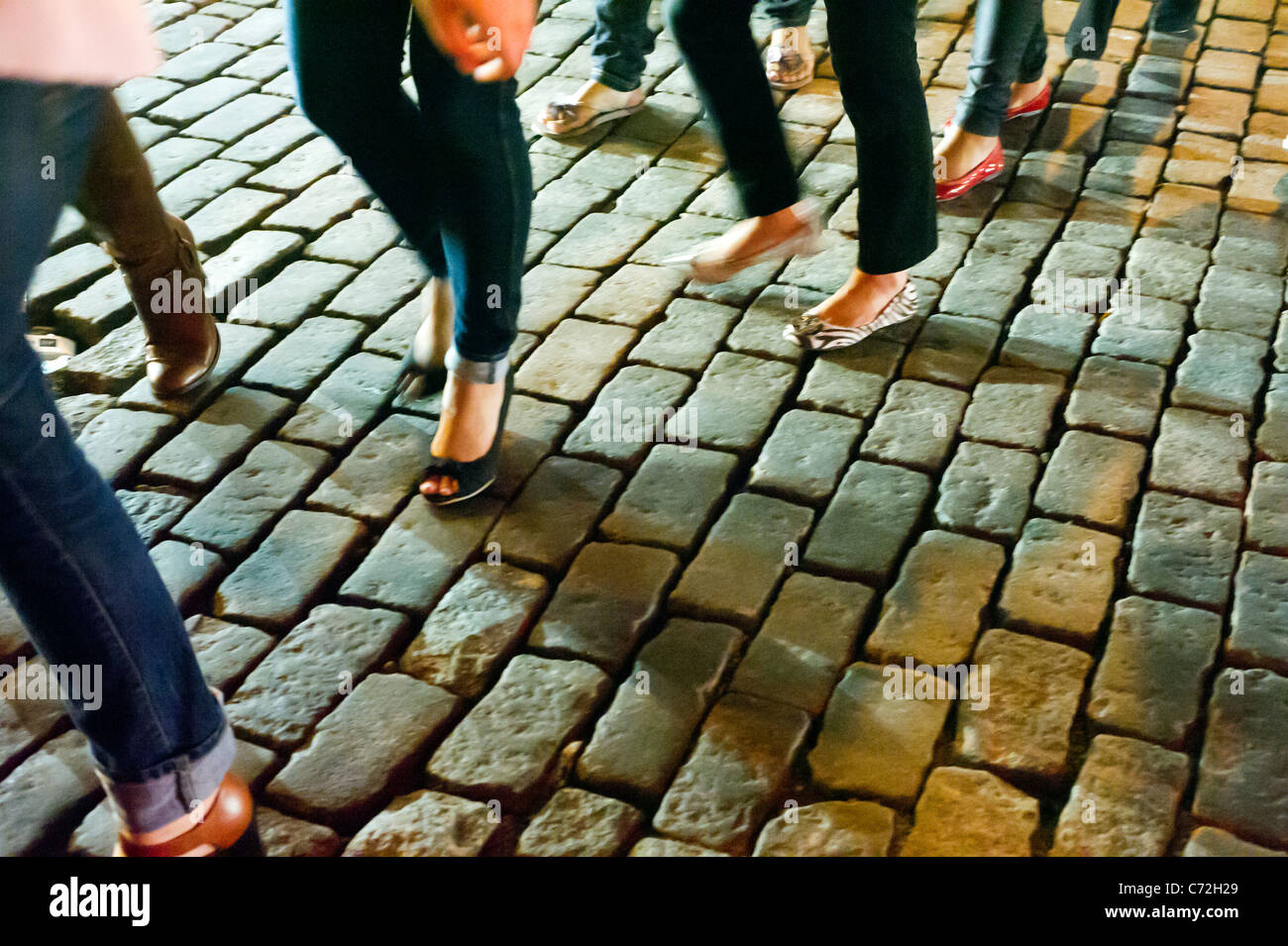 Fashionistas maneuver the cobblestone streets in their designer shoes