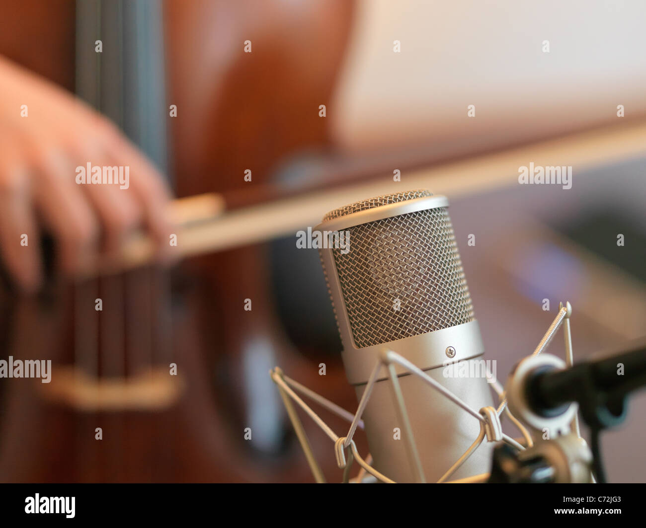 Cello recording with a Neumann D-01 digital microphone. Cello with the bow  blurred in the background Stock Photo - Alamy