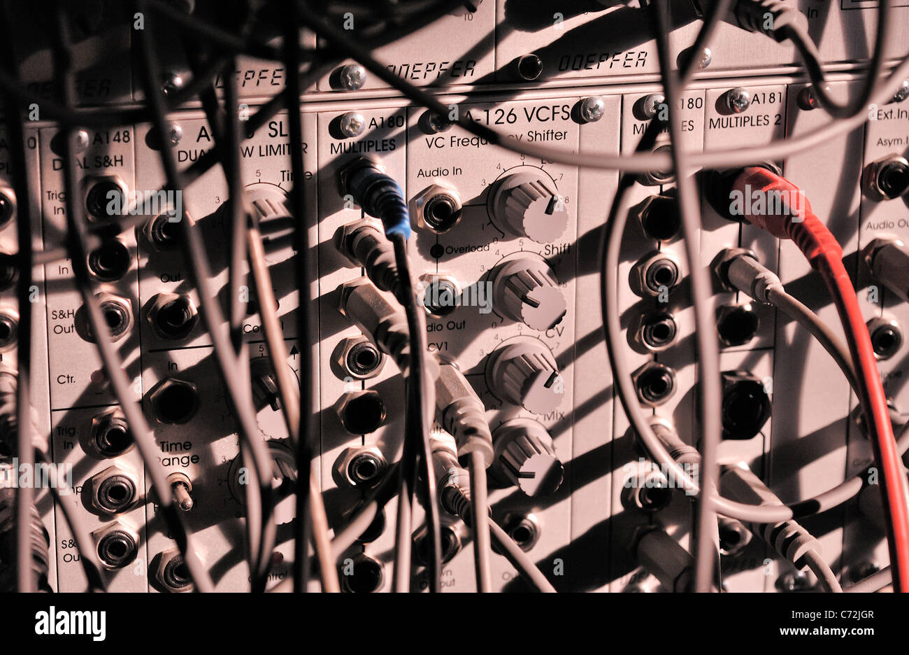 Silver modular synthesizer, with jacks, cables and knobs Stock Photo