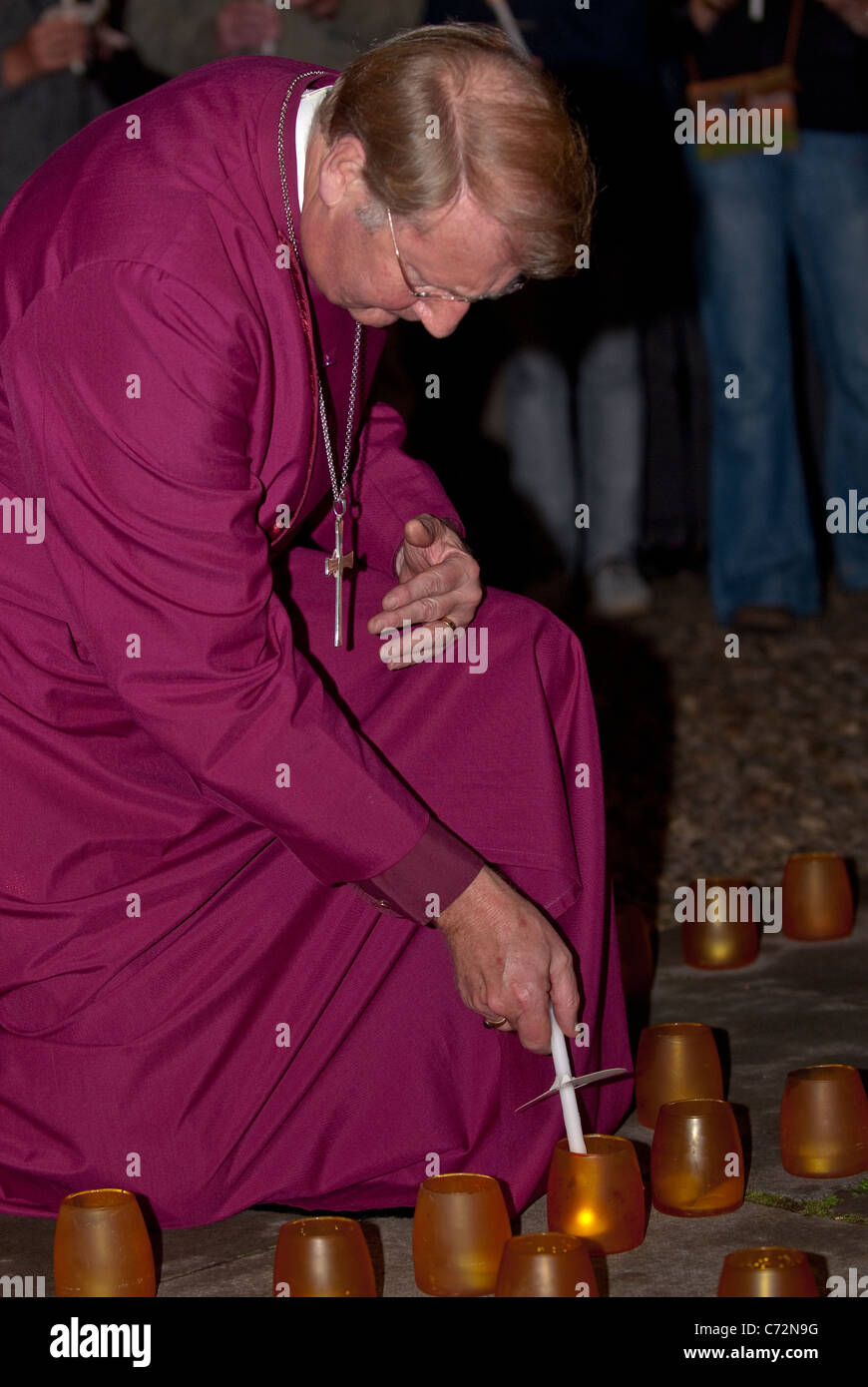 The Rt Revd Michael Langrish Bishop of Exeter lighting a candle at the Peace walk for Interdependence at Exeter Cathedral Stock Photo