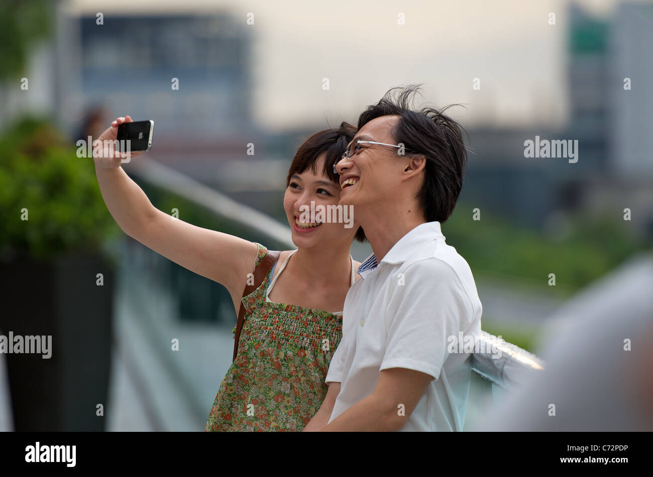 A young Chinese couple taking selfie photos in Hong Kong with an Apple ...