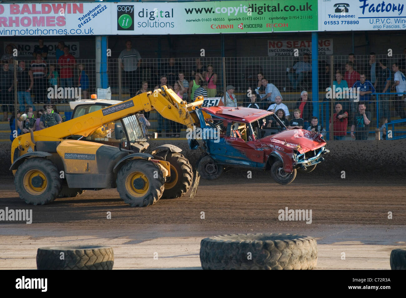 jcb lifting car of track after a banger race Stock Photo