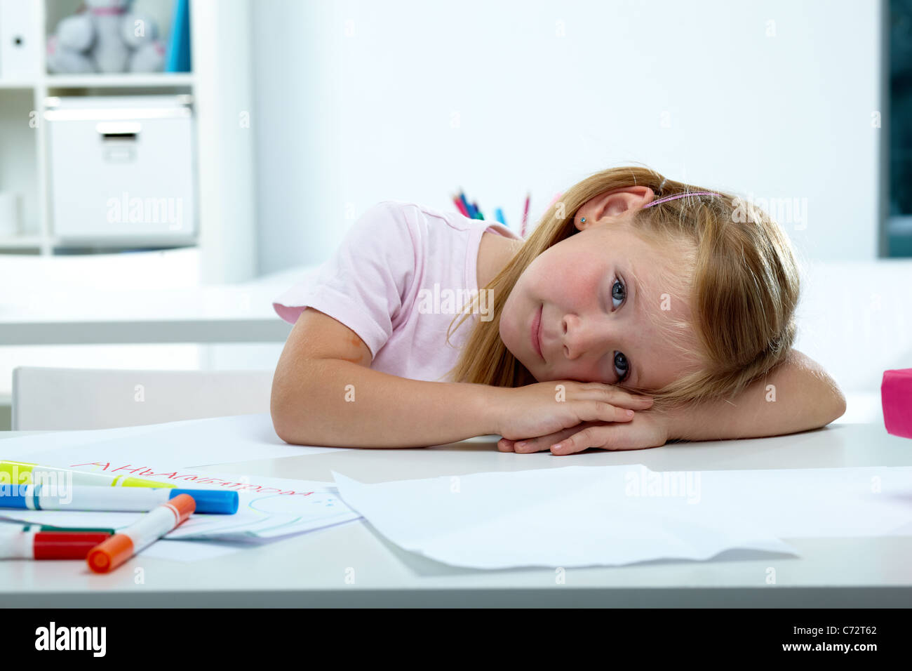 Portrait of lovely girl putting her head on desk Stock Photo