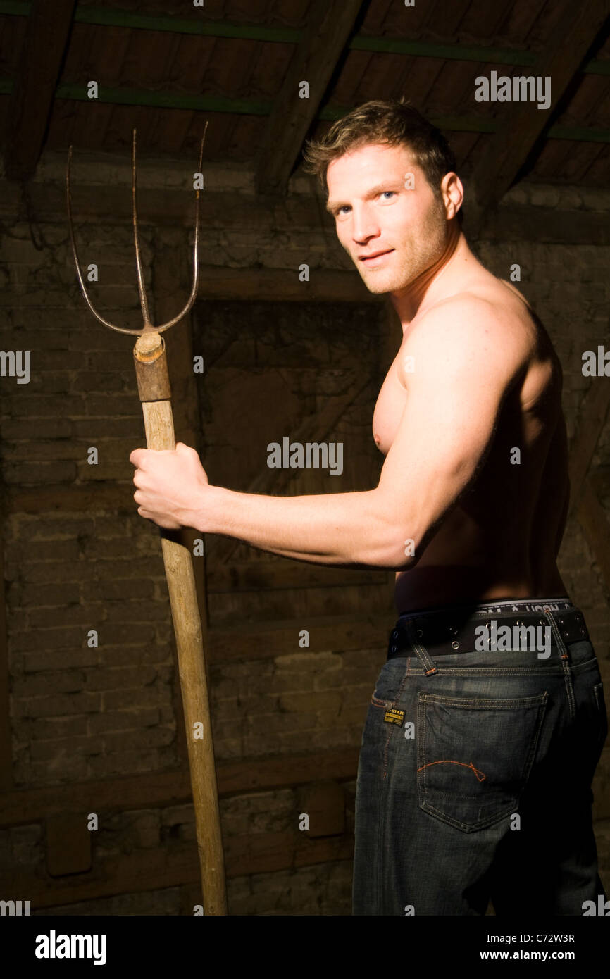 Young man holding a pitchfork Stock Photo