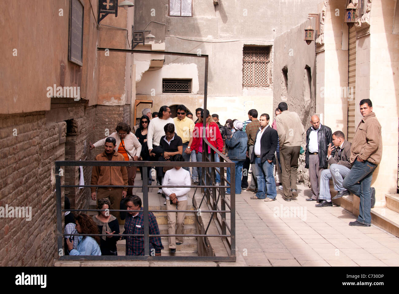 Tourists entering Saint Sergius Church in the coptic quarters in Cairo, Egypt. Entrance is underground and a queue was formed Stock Photo