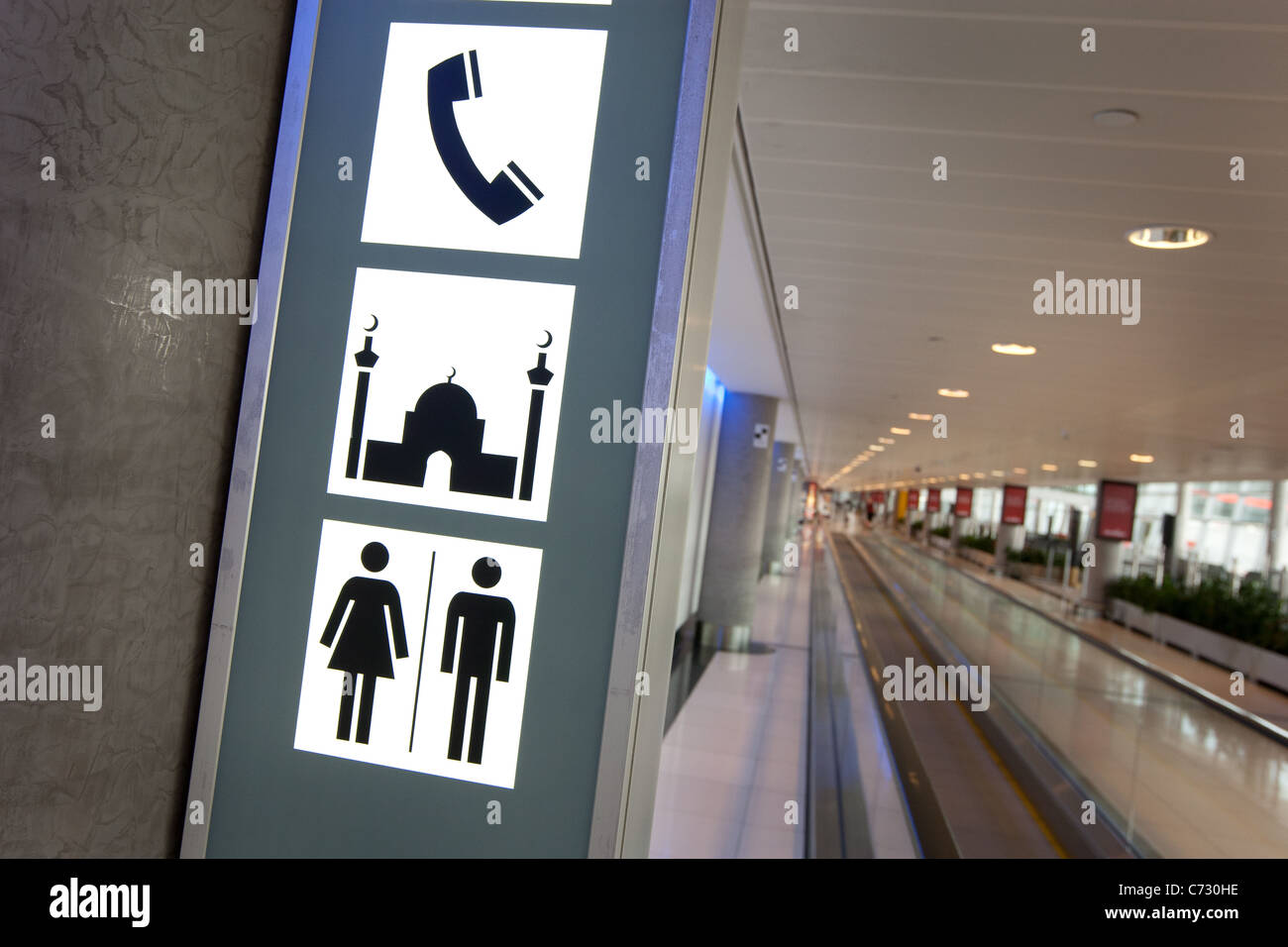 Signs in Abu Dhabi airport indicating location of mosque prayer room, telephones and toilets. Abu Dhabi, UAE. Stock Photo