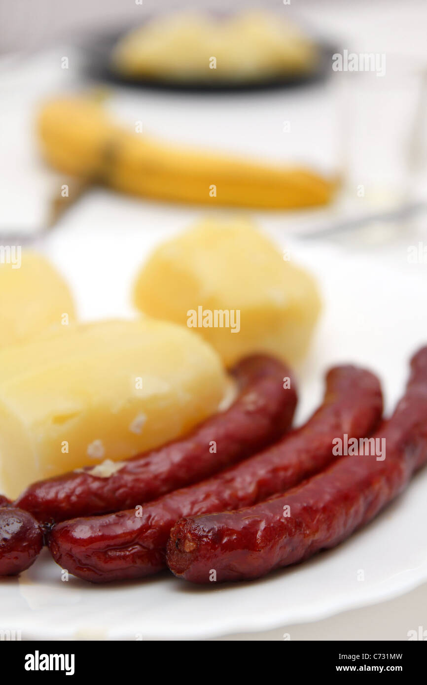Fried sausages and boiled potatoes, closeup on plate Stock Photo