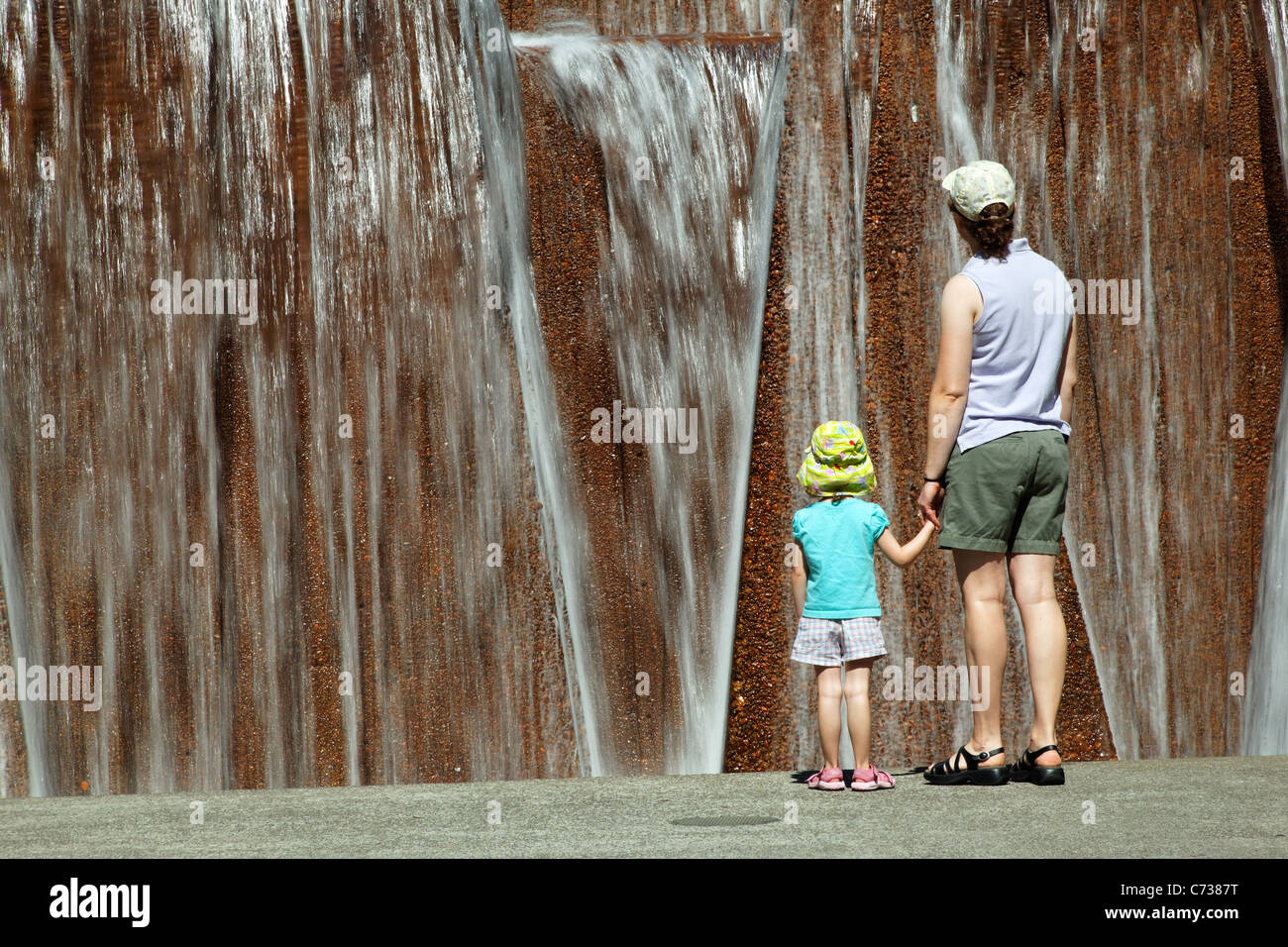Mother and daughter enjoying water fountain, Keller Fountain Park, Portland, Multnomah County, Oregon, USA Stock Photo