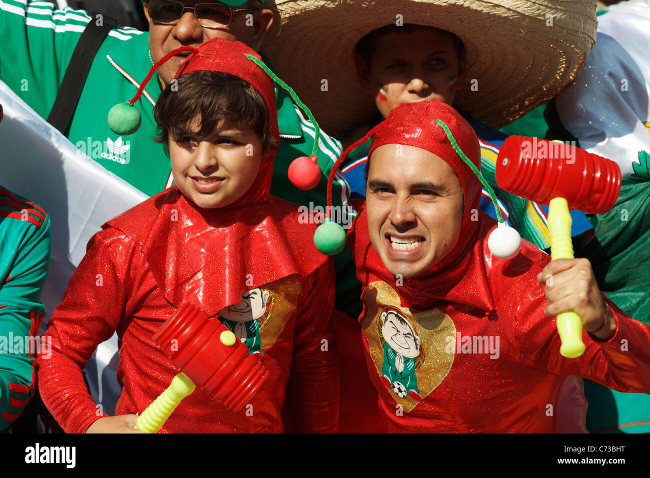 Colorfully clad Mexico supporters gesture at the opening match of the 2010 FIFA World Cup between South Africa and Mexico. Stock Photo