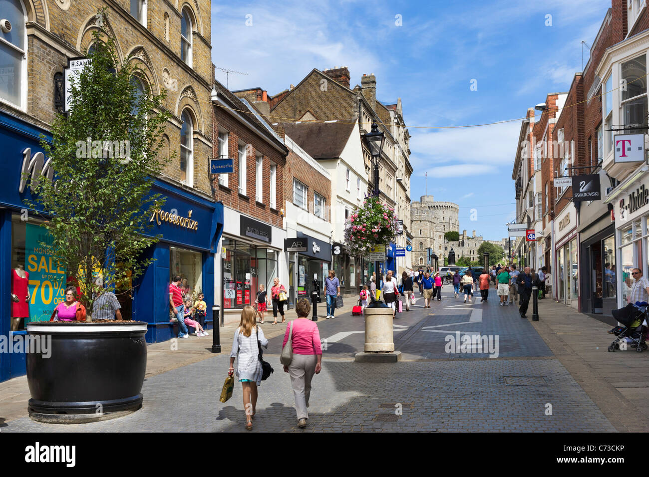 Shops on Peascod Street in the town centre with Windsor Castle in the distance, Windsor, Berkshire, England, UK Stock Photo