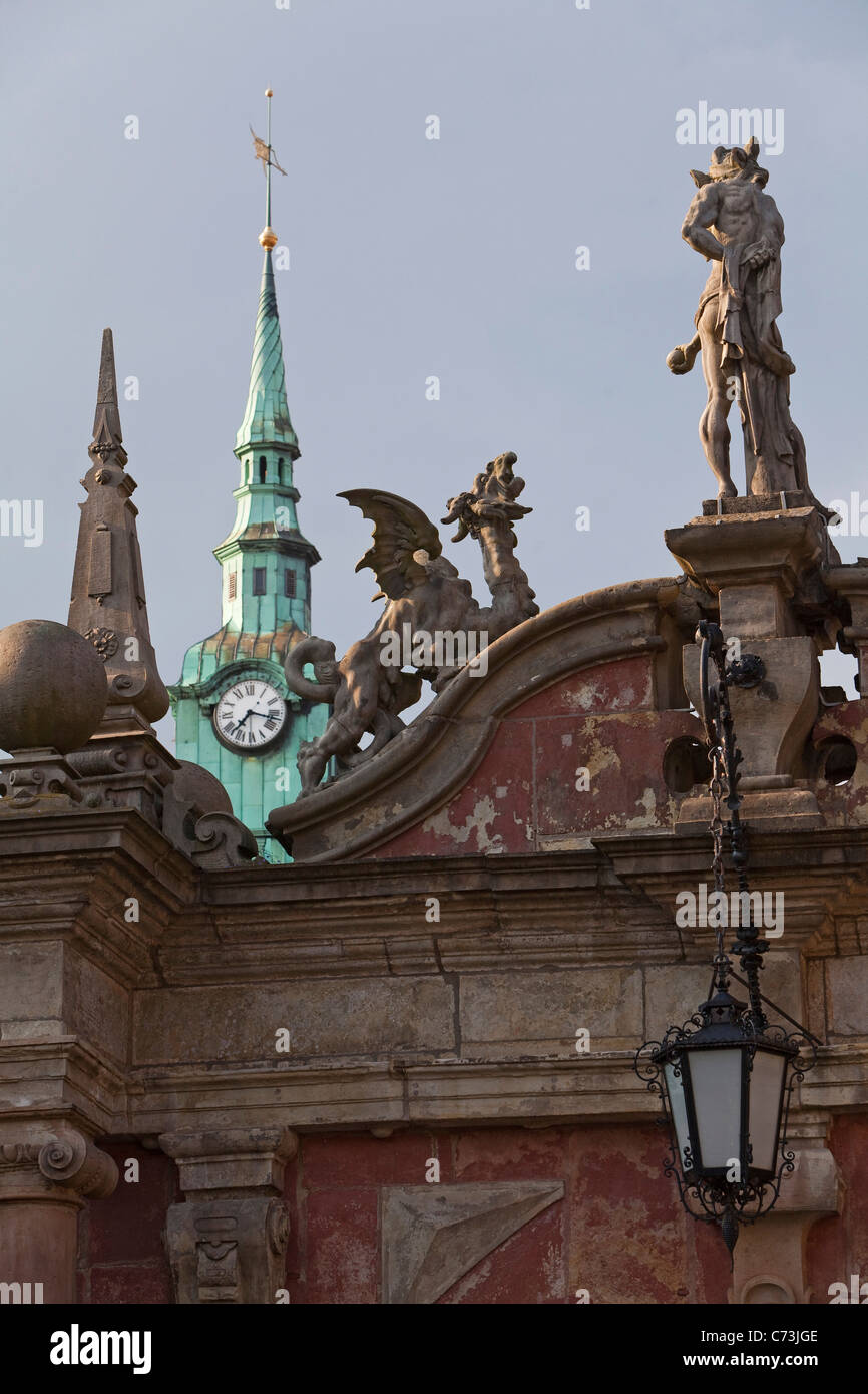 Sculptures on the gates to Bueckeburg Palace with clock tower of the town hall in the background Bueckeburg Lower Saxony norther Stock Photo