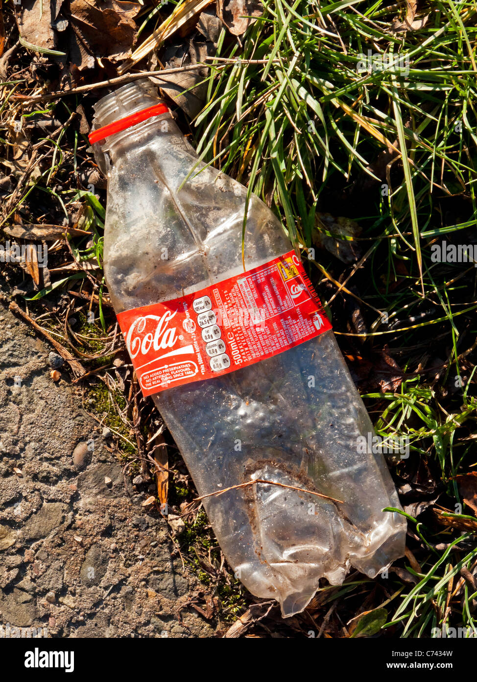 Plastic Coca Cola bottle discarded and left in the countryside in Britain Stock Photo