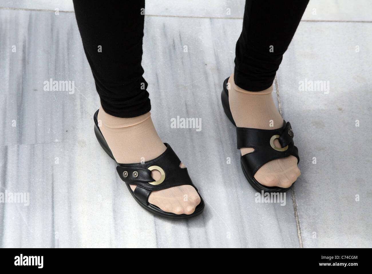 Feet in black sandals Stock Photo