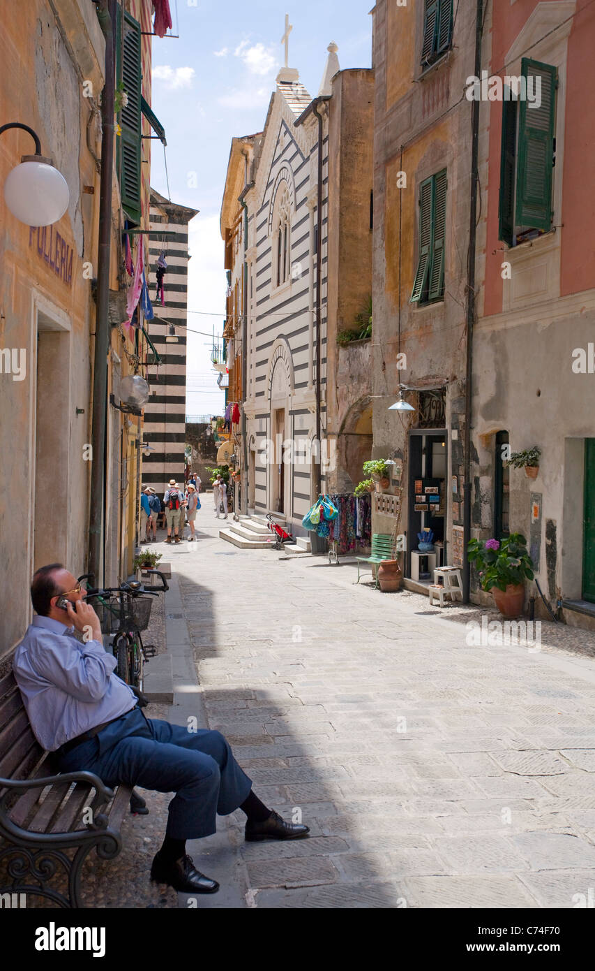 Local phoning on a bench, old town, Monterosso al Mare, Cinque Terre, Unesco World Heritage site, Liguria di Levante, Italy, Mediterranean sea, Europe Stock Photo