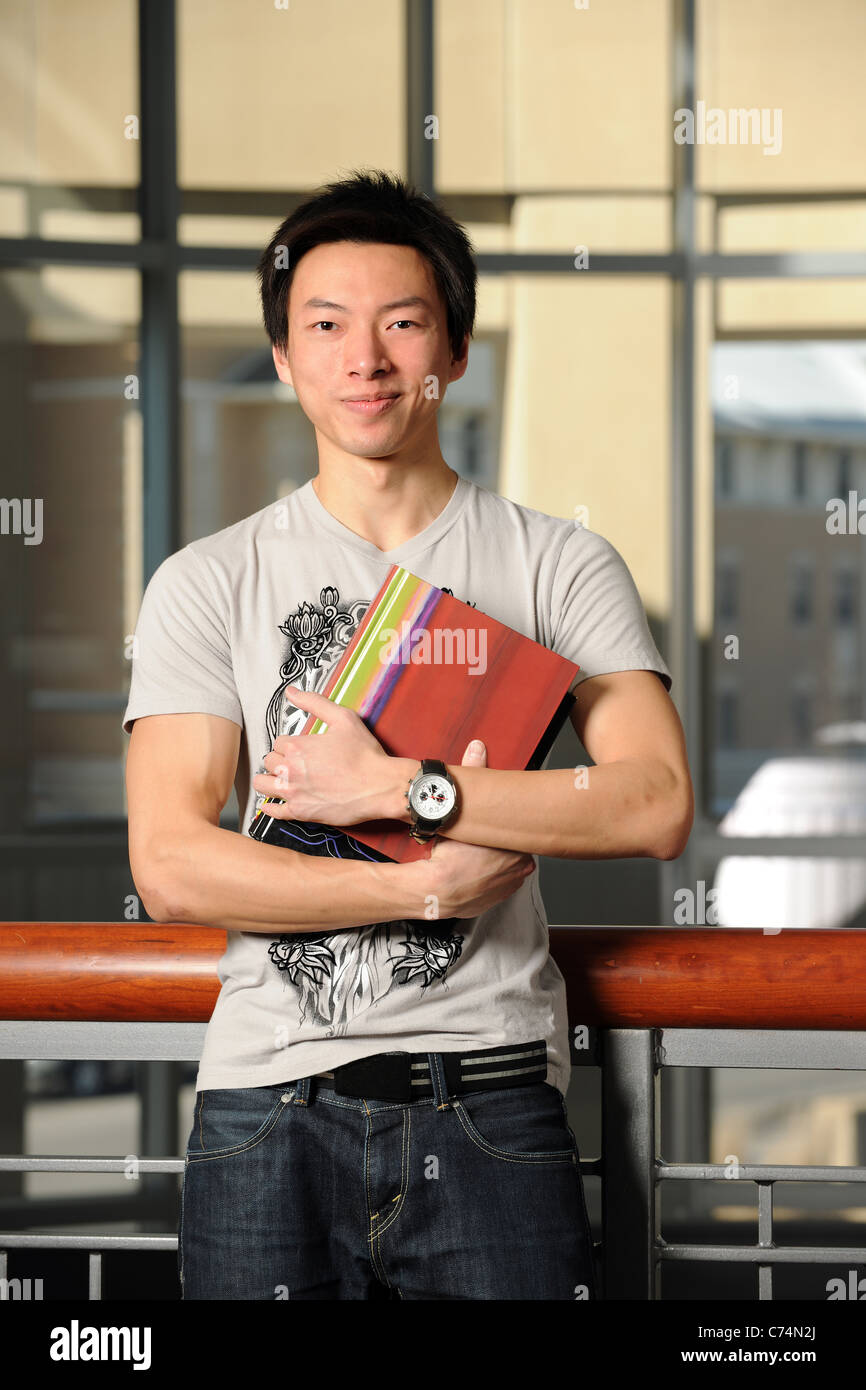 Portrait of Asian student holding book indoors Stock Photo - Alamy