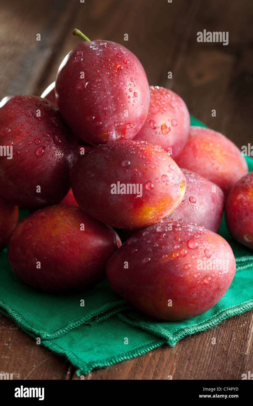 Fresh Plums Pyramid with Green Napkin on Wood Stock Photo